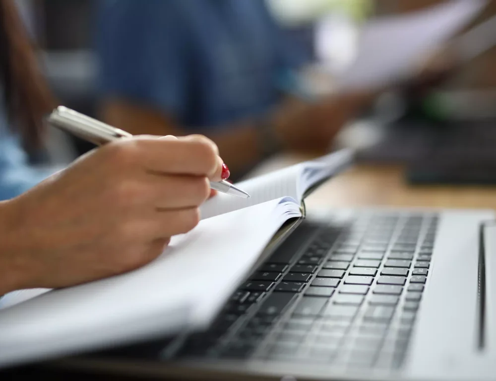 Closeup of woman writing in a notepad