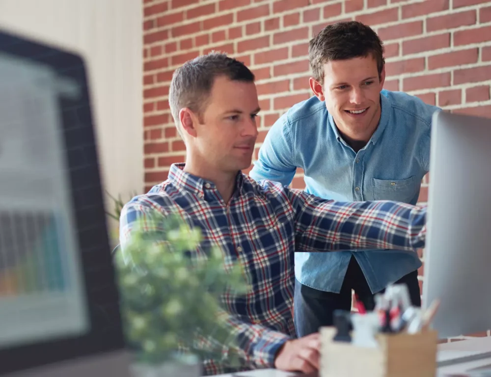 coworkers looking over copywriting on a imac