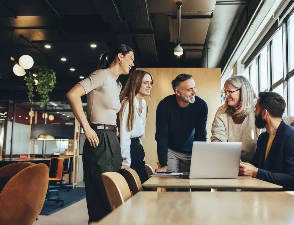 Creative marketing agency empoyees gathered around a laptop