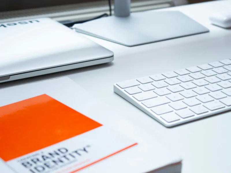 Branding document next to an Apple keyboard.