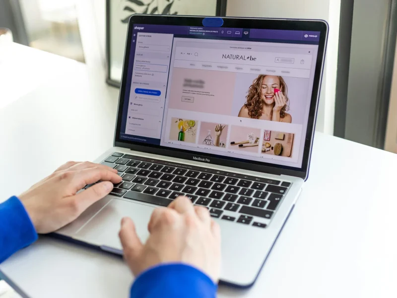 Hands typing on a laptop, shopping online.