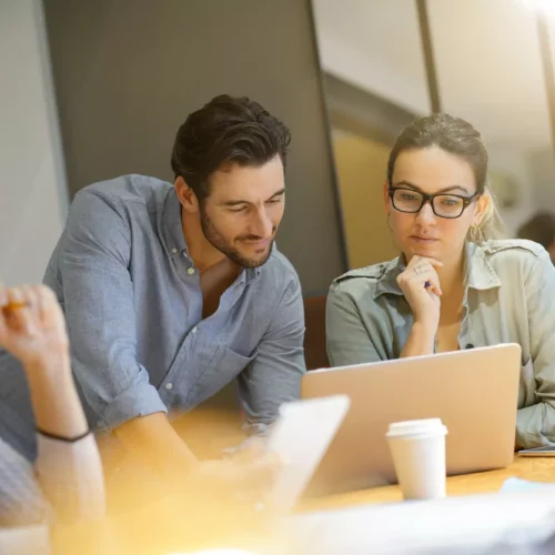 Man and woman reviewing copywriting on a laptop