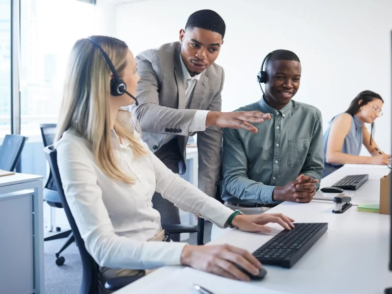 Employees wearing headsets in a telecoms office