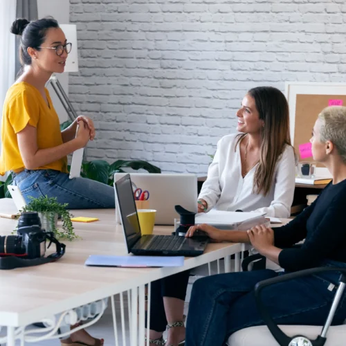 Coworkers talking about a project around a table